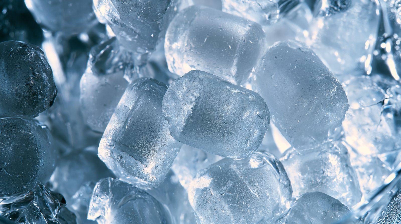 Clear cylindrical ice cubes from a countertop machine, backlit